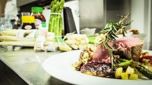 Rosa gebratene Lammkrone mit Apfel-Senfkruste auf Kartoffel-Mostrisotto