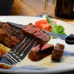 Rosa gebratenes Kalbsrückensteak an weißem Spargel mit Sauce Hollandaise und Reiberdatschi
