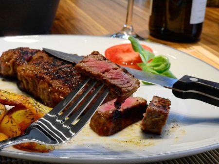 Rosa gebratenes Kalbsrückensteak an weißem Spargel mit Sauce Hollandaise und Reiberdatschi
