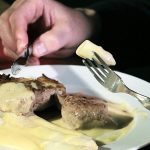 Rosa gebratenes Kalbsrückensteak an weißem Spargel mit Sauce Hollandaise und Reiberdatschi